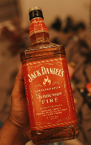 Hand holding a bottle of Jack Daniel's Tennessee Fire Whiskey
